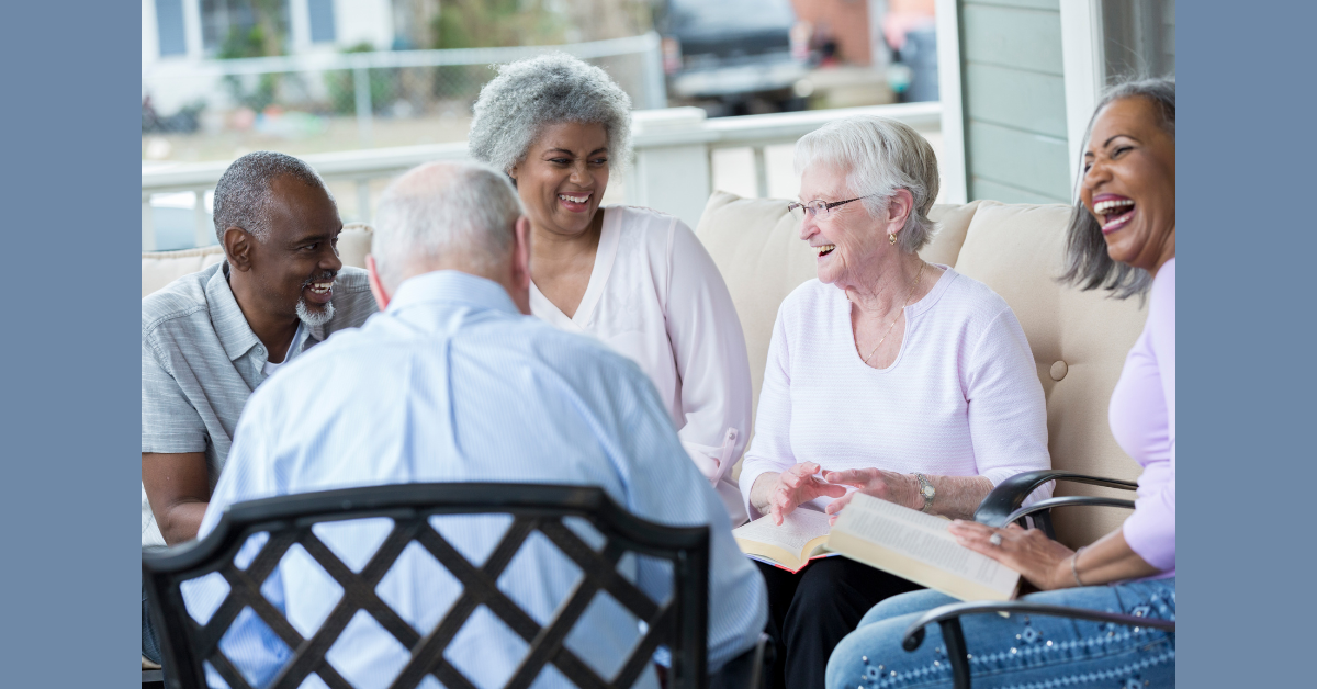 A group of seniors sitting in a circle, talking and smiling